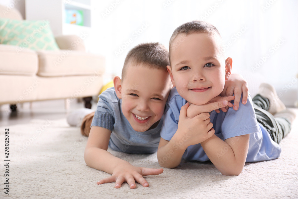 Portrait of cute twin brothers on floor in living room Portrait of cute twin brothers on floor in living room