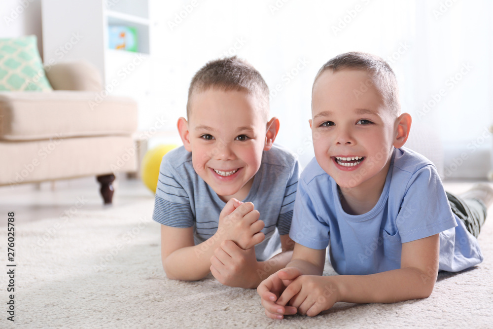 Portrait of cute twin brothers on floor in living room Portrait of cute twin brothers on floor in living room