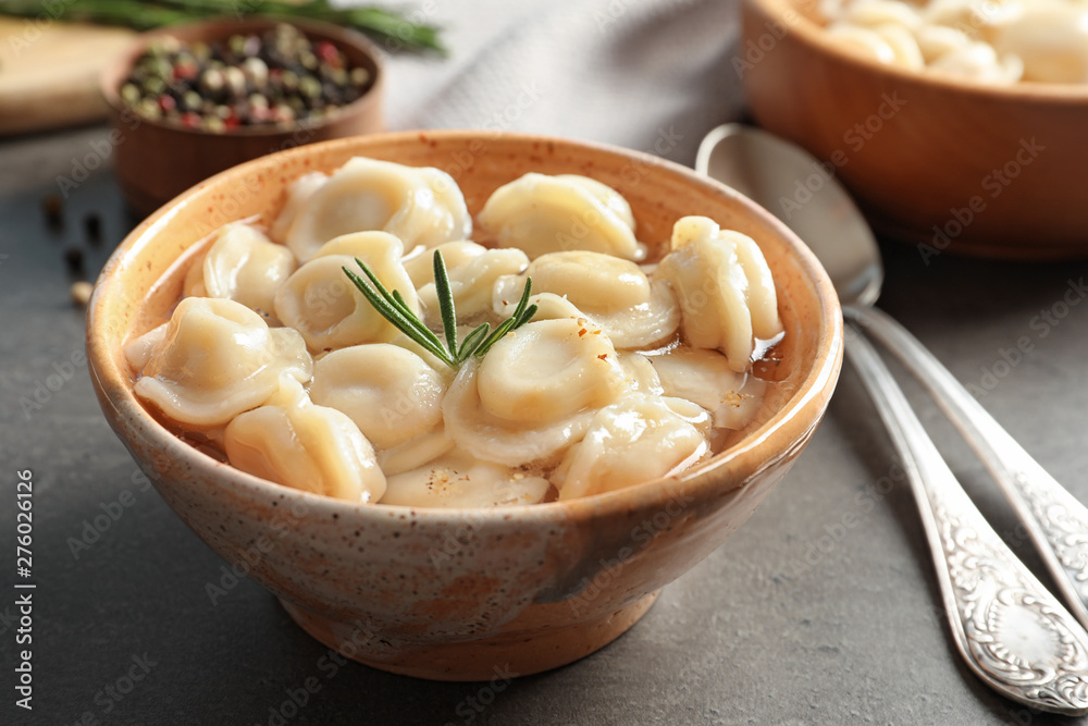 Bowl of tasty dumplings in broth served on grey table Bowl of tasty dumplings in broth served on grey table