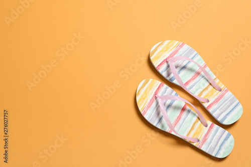 Bright flip flops on color background, top view with space for text. Beach accessories