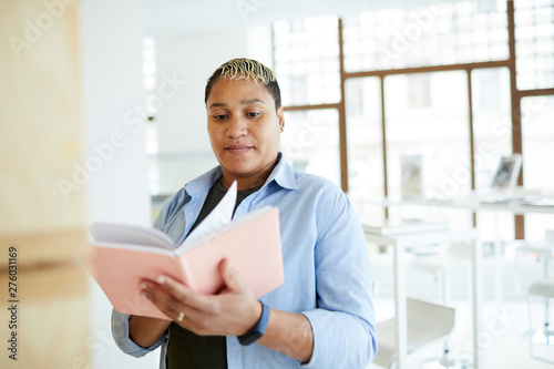 Photography Content portly young mixed race woman with black and blond hair standing in book