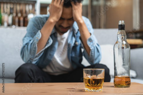 Alcoholism concept. Young man drinking alcohol too much. photo
