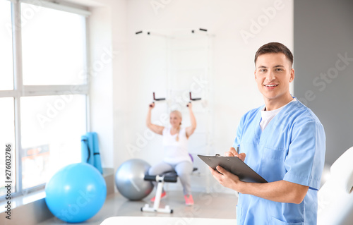 Young male physiotherapist in rehabilitation center photo