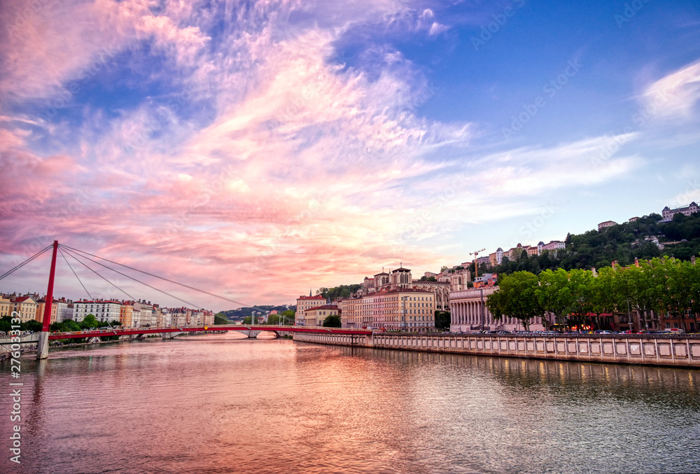 Obraz premium A view of Lyon, France along the Saône river at sunset.