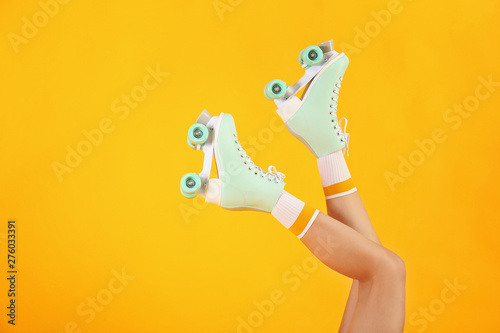 Foto Legs of woman in roller skates on color background