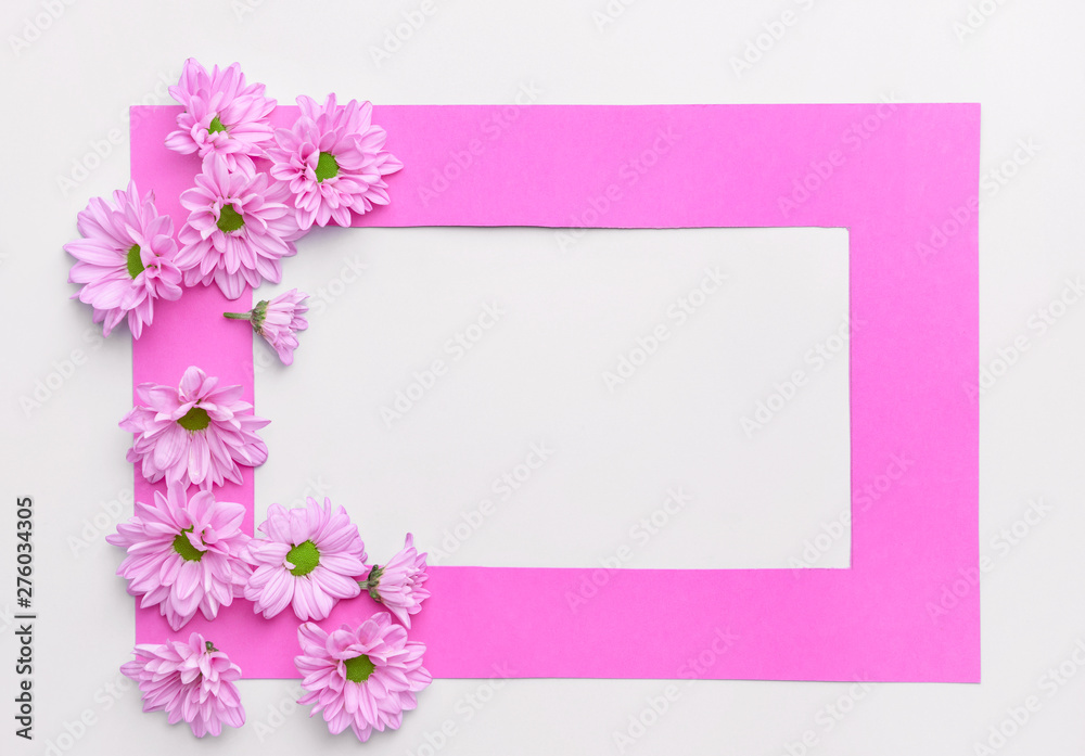 Beautiful fresh flowers and frame on light background