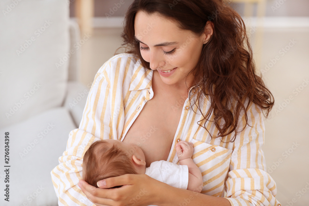 Young woman breastfeeding her baby at home Young woman breastfeeding her baby at home