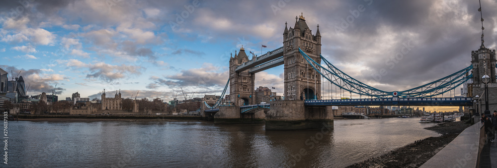 Fototapeta Londyn, Anglia, 10 grudnia 2018 r .: Tower Bridge w Londynie, Wielka Brytania. Wschód słońca z pięknymi chmurami. Panoramiczny widok z Białą Wieżą i kula jak budynek. Angielskie symbole