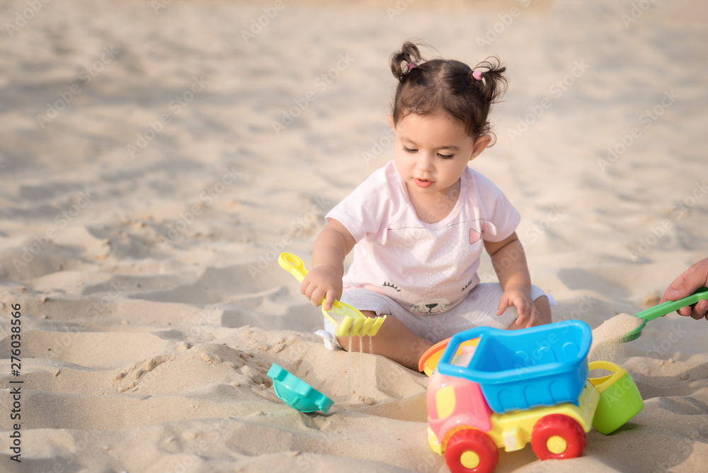 Beautiful sweet Baby girl playing on the sandy summer beach near the sea. Travel and vacation with children, Holiday concept. Summer Fun Or Best Warm Winter Family Vacations. Beautiful sweet Baby girl playing on the sandy summer beach near the sea. Travel and vacation with children, Holiday concept. Summer Fun Or Best Warm Winter Family Vacations.