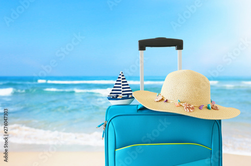 holidays. travel concept. blue suitcase infront of tropical background