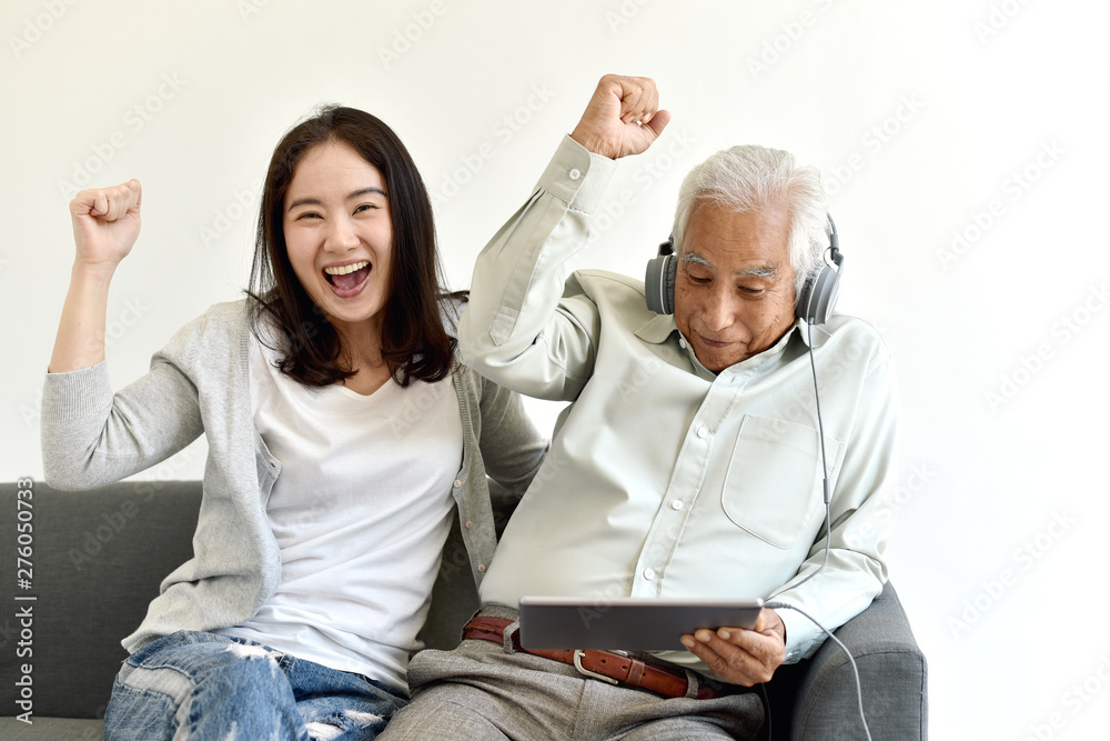 Happy family time, Smiling asian daughter and elderly father enjoy watching movie from laptop computer together, Senior people and social media lifestyle concept.