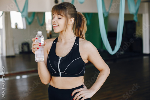 Beautiful girl in the gym. A woman in a black sportsuit photo