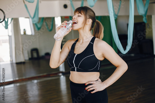 Beautiful girl in the gym. A woman in a black sportsuit photo