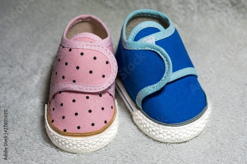 Blue and pink baby shoes on white textured background