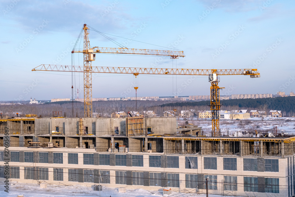 large tower cranes in winter on the construction