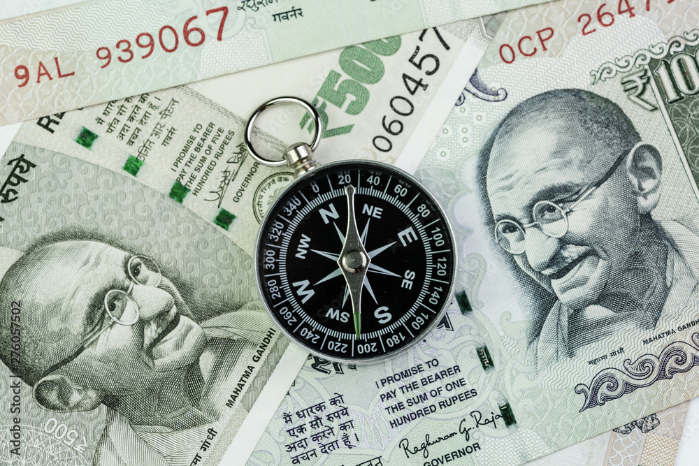 Compass on Indian Rupee banknotes money using as India economic problem solving, financial direction or key to get success in world competition Compass on Indian Rupee banknotes money using as India economic problem solving, financial direction or key to get success in world competition