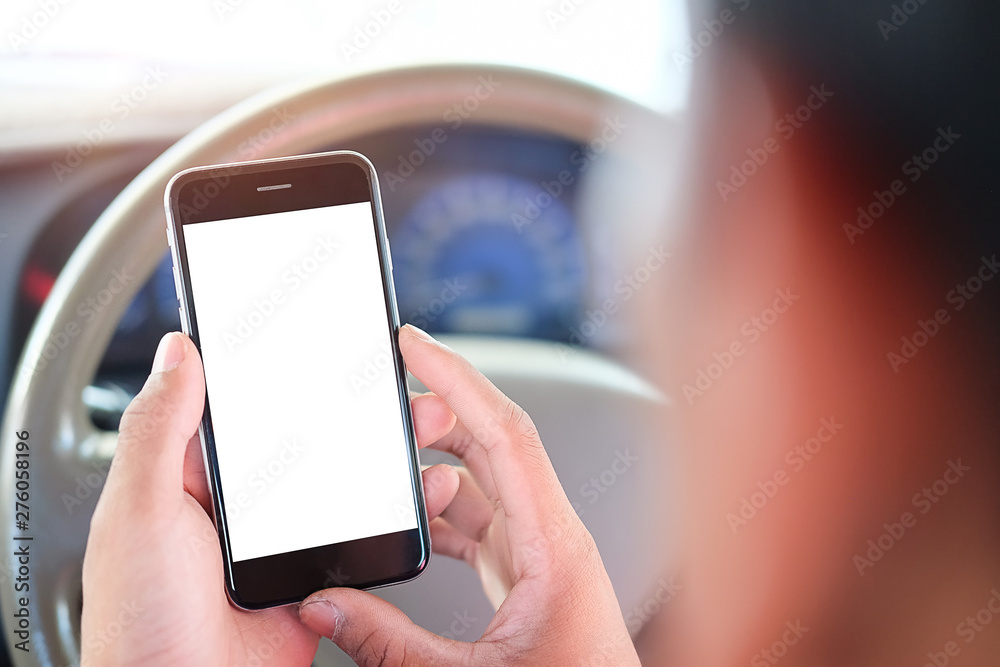 Cropped shot view The driver uses the phone while driving. Modern smart phone with round edges. Isolated screen for mockup. Car navigation display in background.