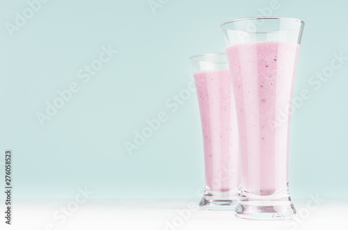 Set of two diet milk beverages with blueberry in elegant glass on pastel soft light blue background, copy space.