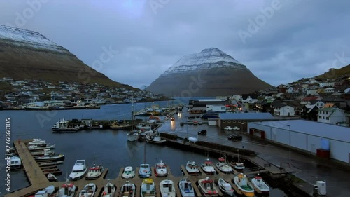 Aerial Ascent Over Village Town on Faroe Islands at Dusk, Snowy Hills in Background, Borooy Island, Faroe Islands photo