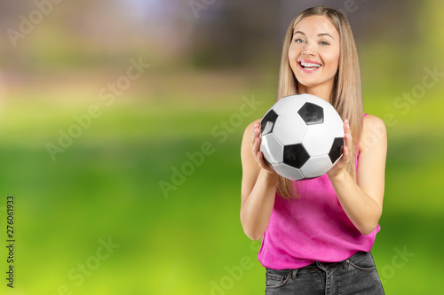 Soccer fan. Young beautiful woman holding soccer ball over isolated background