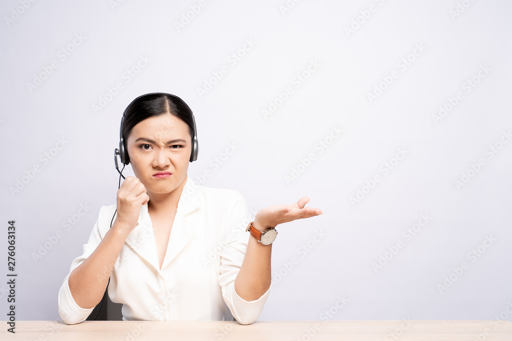 Woman operator in headset feel angry over white background Woman operator in headset feel angry over white background