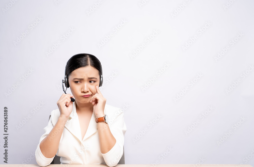 Woman operator in headset feel confuse over white background Woman operator in headset feel confuse over white background