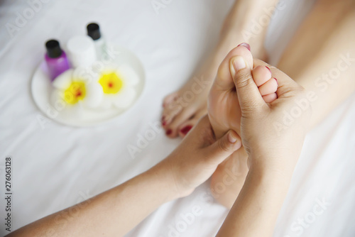 Woman receiving foot massage service from masseuse close up at hand and foot - relax in foot massage therapy service concept