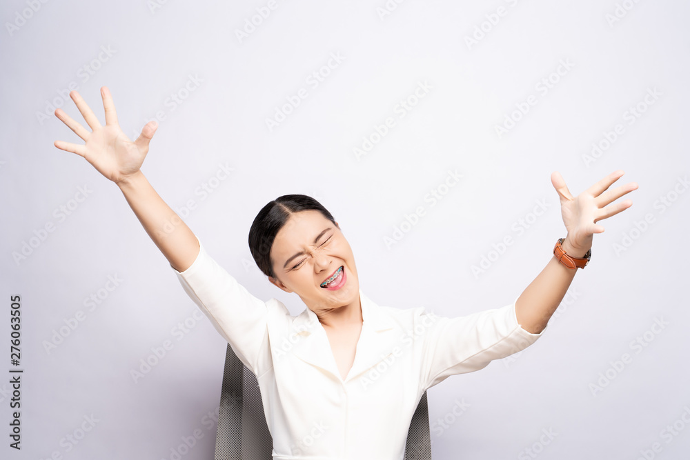 Happy woman make winning gesture sitting isolated over white background Happy woman make winning gesture sitting isolated over white background