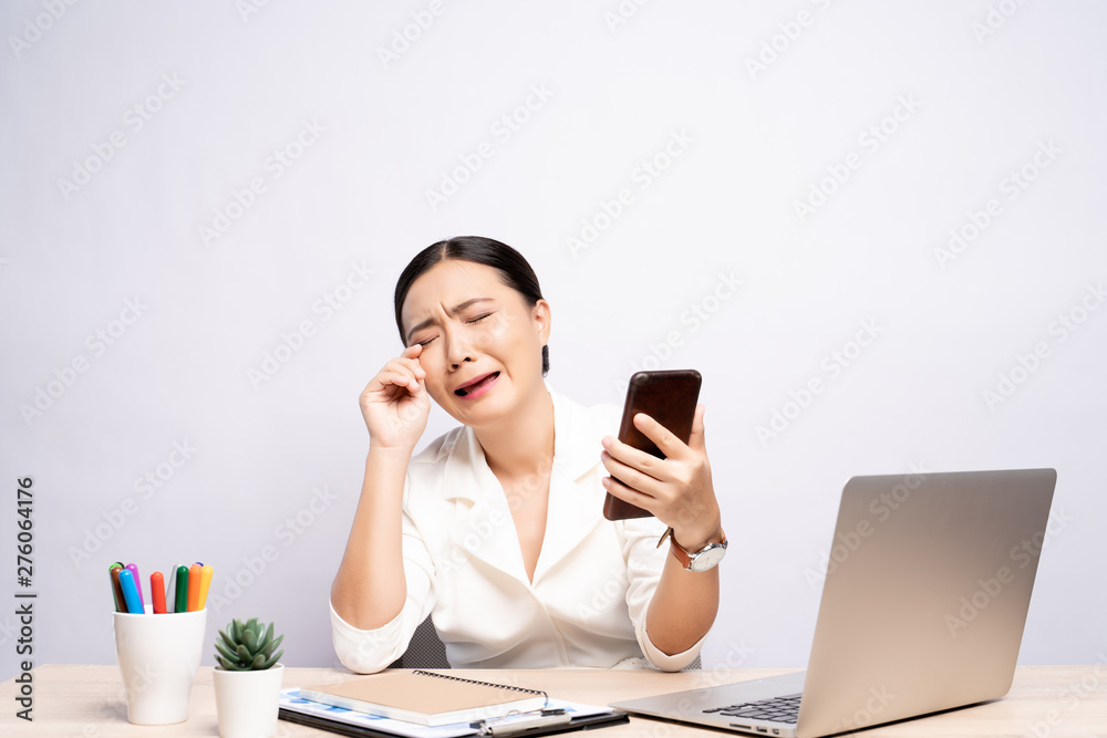 Portrait of sad woman used smartphone at office isolated over background Portrait of sad woman used smartphone at office isolated over background
