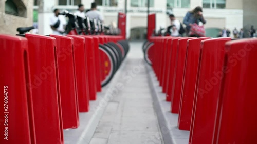 Wallpaper Mural Red bicycle docks in the centre of Barcelona. Wheels and metallic parts of a bike stations. People walking around the square near museum of contemporary art.  Torontodigital.ca
