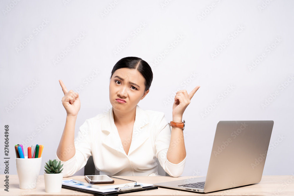 Portrait of a confused woman sitting at office isolated over background Portrait of a confused woman sitting at office isolated over background