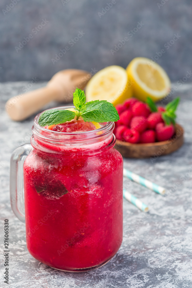 Refreshing raspberry, lemon and mint lemonade with sparkling water in jar, vertical