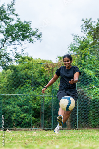 beautiful sporty indian athlete woman playing football