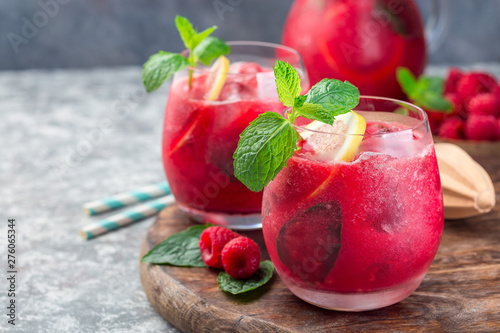 Refreshing raspberry, lemon and mint lemonade with sparkling water in  glass, horizontal, copy space