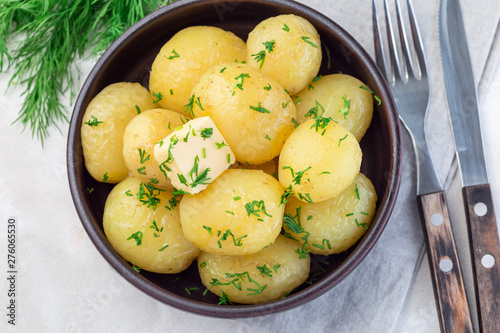Murais de parede New young boiled  potato topped with melted butter and chopped dill in ceramic b