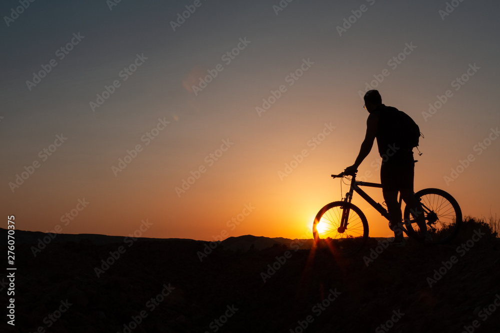 Man with mountain bike at sunrise