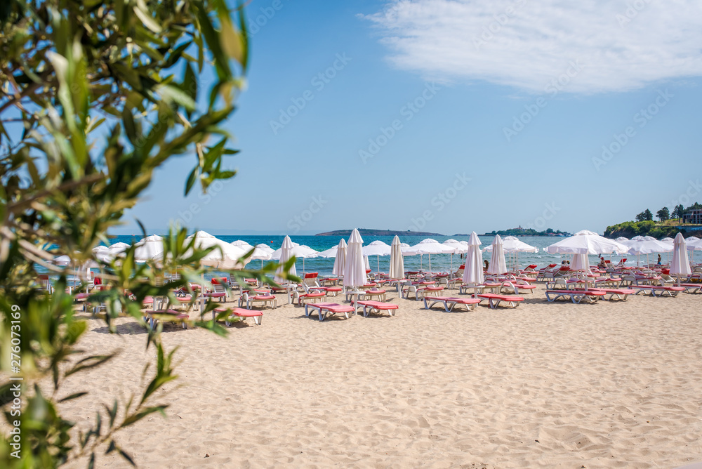 Summer beach with deck chairs and umbrellas. 