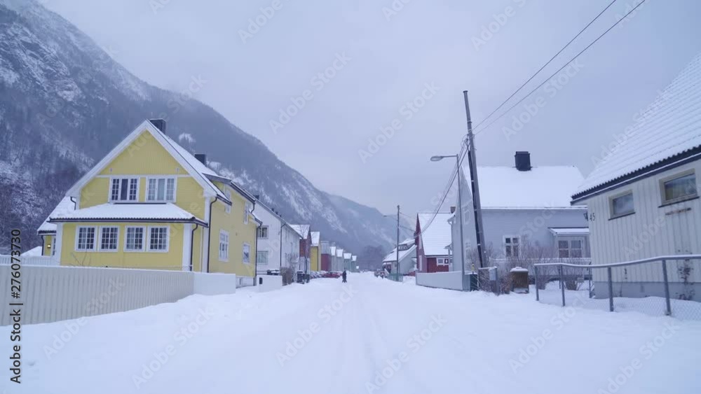 Steadicam through traditional snow covered street in Norway with mountainous backdrop Steadicam through traditional snow covered street in Norway with mountainous backdrop