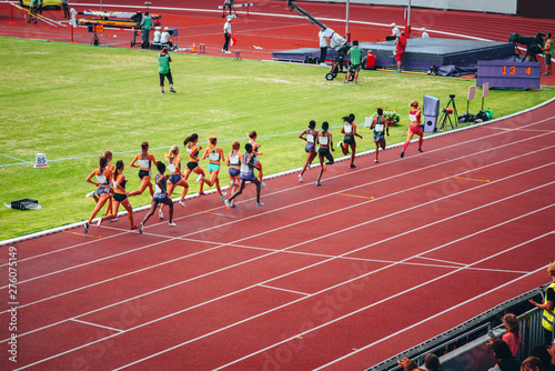 Female track and field race at athletics stadium. Professional female runners. Photo for athletics competition at summer olympic game Tokyo 2020.