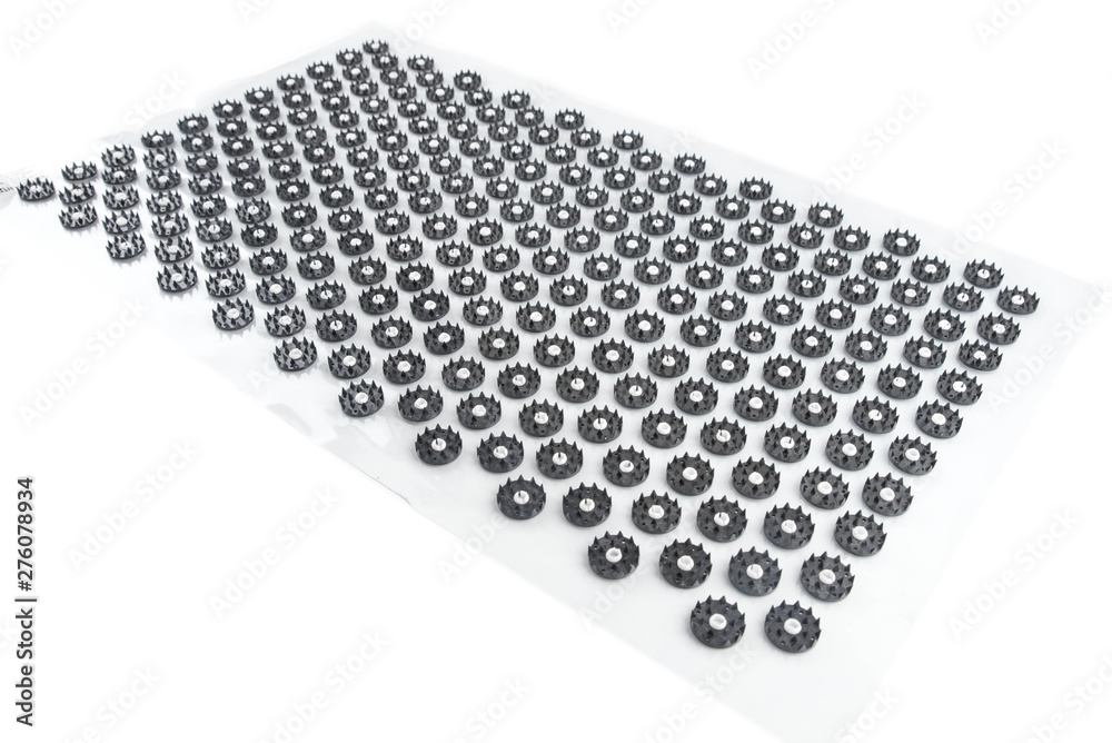 Fototapeta premium Acupuncture orthopedic massage mat with needles and spikes for feet and body isolated on white background. Alternative medicine, health care, recreation and muscle relaxation concept.