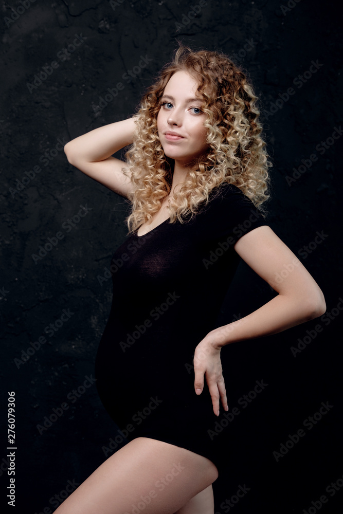 pregnant young woman in studio on black background