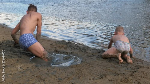 boy playing with sand on the beach
