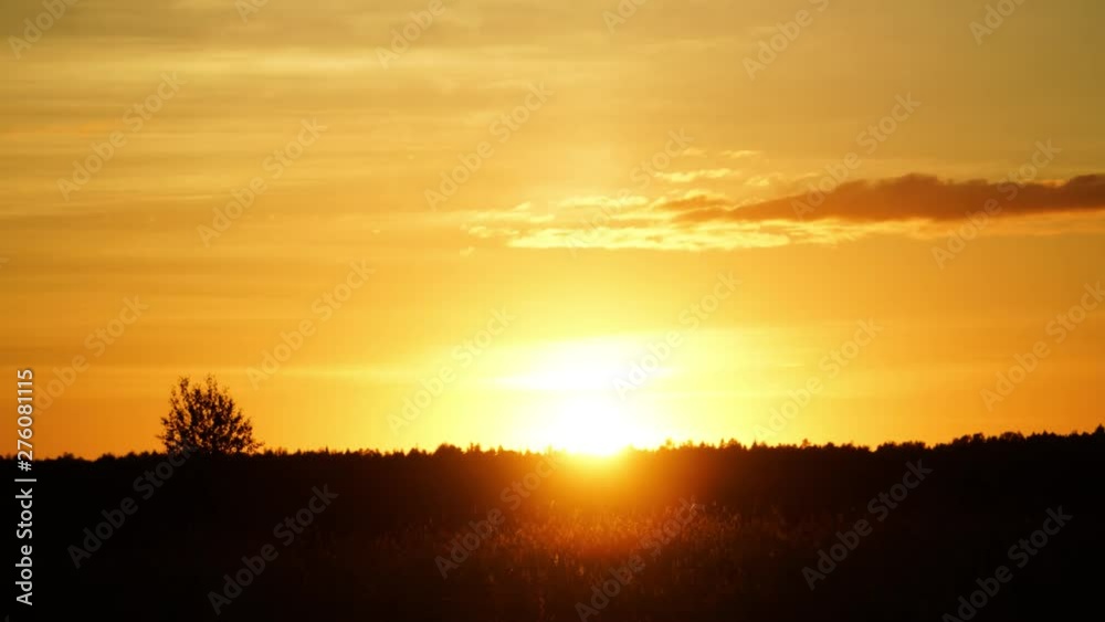 The sun slowly sets behind the forest. The sun slowly sets behind the forest.