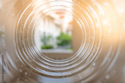 The building through a plastic bottle with a blurred bottle on blurred natrue background. decoration image contain certain grain  noise and soft focus.