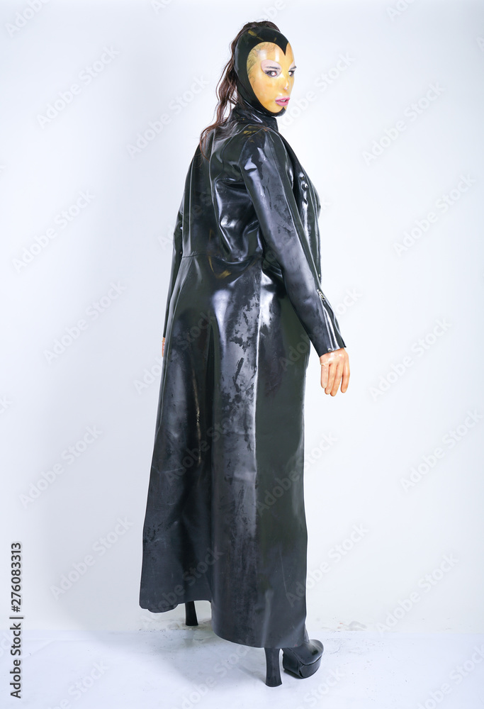Foto de Plus size woman in latex suit and leather boots in thick heavy  rubber raincoat on white background in Studio. hot fashionable adult girl  posing in fetish clothes alone isolated hot