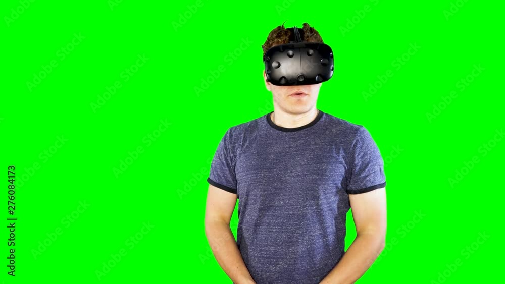 Man stops playing and takes off VR helmet. Playing virtual reality on green screen. Person looking at game world enjoying futuristic virtual entertainment at home. Fun modern video games. Man stops playing and takes off VR helmet. Playing virtual reality on green screen. Person looking at game world enjoying futuristic virtual entertainment at home. Fun modern video games.