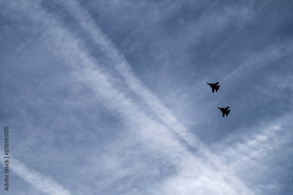silhouettes of fighters are flying in the sky
