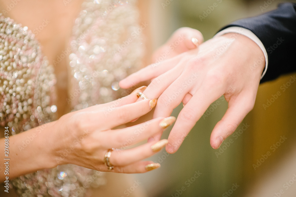 The bridegroom puts the wedding ring on the bride close up. The bride puts the bridegroom on the wedding ring. The bridegroom puts the wedding ring on the bride close up. The bride puts the bridegroom on the wedding ring.