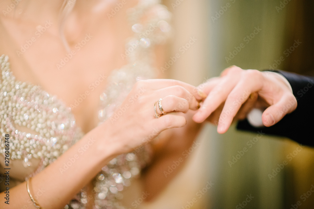 The bridegroom puts the wedding ring on the bride close up. The bride puts the bridegroom on the wedding ring. The bridegroom puts the wedding ring on the bride close up. The bride puts the bridegroom on the wedding ring.