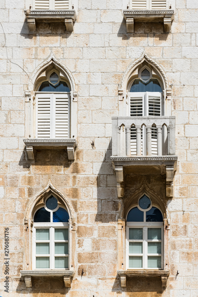 facafacade of white brick house with balcony and decorative windows in historical town Porec, Croatiade of white building white windows, balcony and shutters in historical town Porec, Croatia
